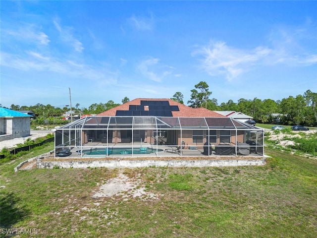 718 Willard Ave, Lehigh Acres, FL 33972 - rear view of house featuring solar panels, an outdoor pool, glass enclosure, and a yard