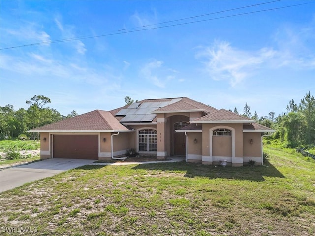 718 Willard Ave, Lehigh Acres, FL 33972 - view of front of property with concrete driveway, a garage, stucco siding, a front yard, and roof mounted solar panels