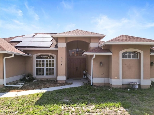 718 Willard Ave, Lehigh Acres, FL 33972 - view of front of property with roof mounted solar panels and stucco siding