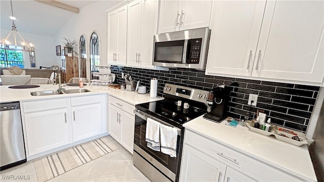 14257 Heritage Landing Blvd Unit 1122, Punta Gorda, FL 33995 - kitchen featuring appliances with stainless steel finishes, a sink, a chandelier, tasteful backsplash, and white cabinetry
