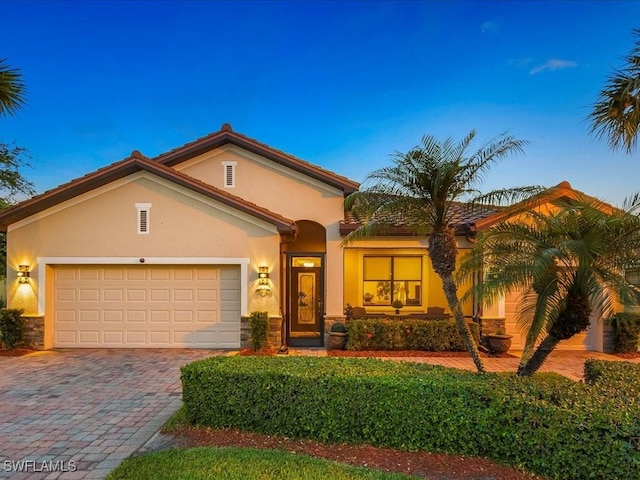 3913 Sapphire Way, Naples, FL 34114 - mediterranean / spanish-style house featuring stucco siding, decorative driveway, a garage, and stone siding
