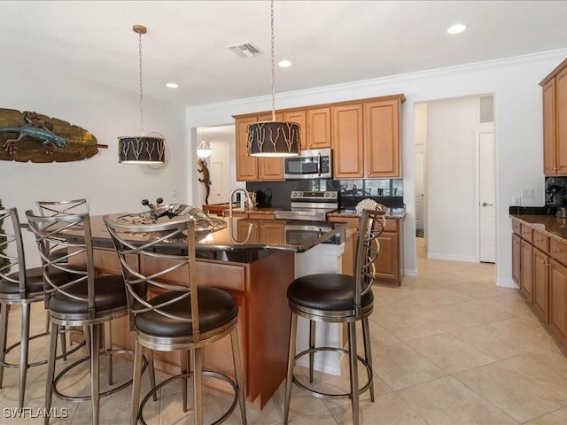 3913 Sapphire Way, Naples, FL 34114 - kitchen featuring appliances with stainless steel finishes, a kitchen bar, a kitchen island with sink, light tile patterned floors, and ornamental molding
