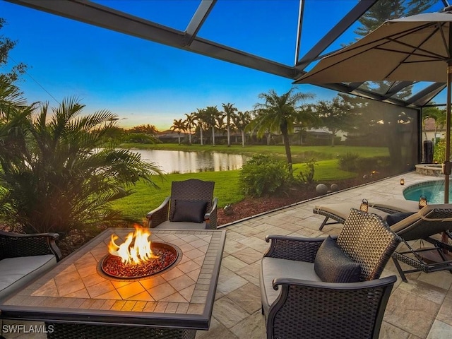 3913 Sapphire Way, Naples, FL 34114 - patio terrace at dusk featuring a fire pit, a water view, a patio area, a lanai, and an outdoor pool