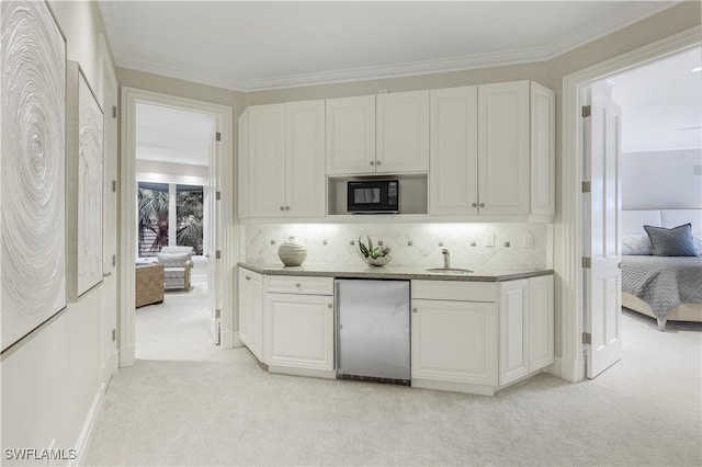 4111 Harbor Oaks Ct, Bonita Springs, FL 34134 - kitchen with fridge, light carpet, black microwave, white cabinets, and crown molding