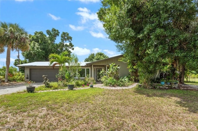 13951 Rod And Gun Club Rd, Fort Myers, FL 33913 - ranch-style house with an attached garage, a front lawn, and asphalt driveway