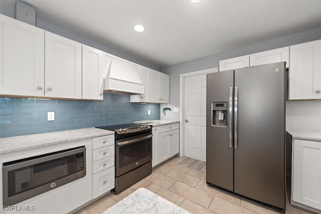 13951 Rod And Gun Club Rd, Fort Myers, FL 33913 - kitchen with stainless steel appliances, premium range hood, white cabinetry, decorative backsplash, and recessed lighting