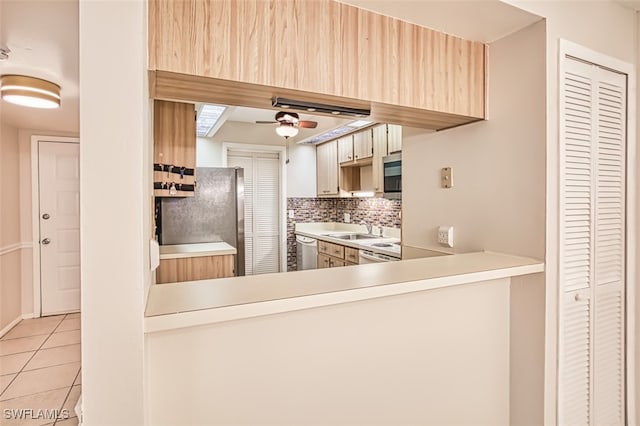 8061 S Woods Cir Unit 4, Fort Myers, FL 33919 - kitchen featuring light brown cabinets, stainless steel appliances, light tile patterned floors, decorative backsplash, and light countertops
