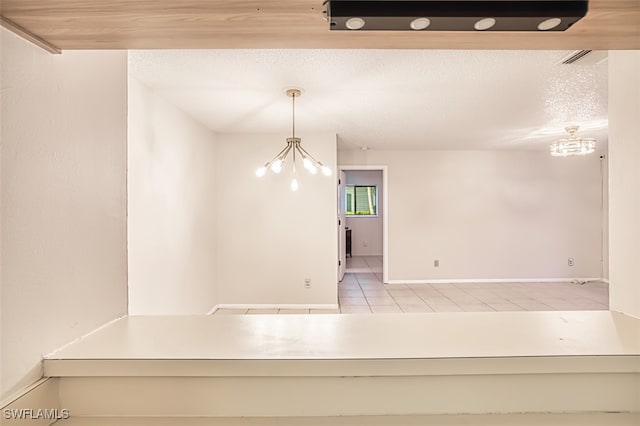 8061 S Woods Cir Unit 4, Fort Myers, FL 33919 - unfurnished dining area featuring a chandelier, tile patterned flooring, baseboards, and a textured ceiling
