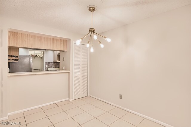 8061 S Woods Cir Unit 4, Fort Myers, FL 33919 - unfurnished dining area with a chandelier, light tile patterned floors, and baseboards