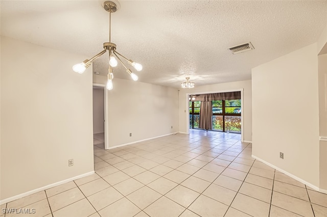 8061 S Woods Cir Unit 4, Fort Myers, FL 33919 - spare room with a textured ceiling, light tile patterned floors, a chandelier, and baseboards