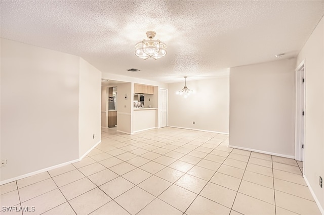 8061 S Woods Cir Unit 4, Fort Myers, FL 33919 - spare room with a chandelier, a textured ceiling, light tile patterned floors, and baseboards