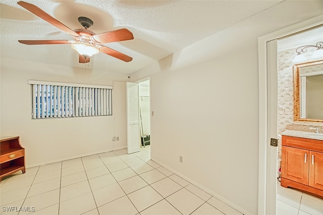 8061 S Woods Cir Unit 4, Fort Myers, FL 33919 - spare room with a ceiling fan, a sink, light tile patterned floors, and a textured ceiling