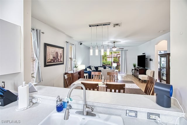 9201 Middle Oak Dr, Fort Myers, FL 33967 - kitchen featuring arched walkways, ceiling fan, a sink, open floor plan, and decorative light fixtures