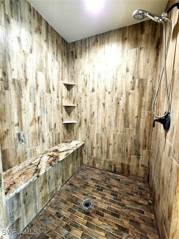 6405 Alan Blvd, Punta Gorda, FL 33982 - bathroom featuring a tile shower and wooden walls