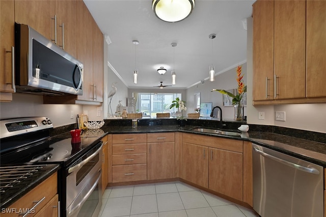 7058 Barrington Cir Unit 102, Naples, FL 34108 - kitchen with appliances with stainless steel finishes, a sink, ornamental molding, dark stone countertops, and brown cabinets