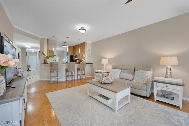 7058 Barrington Cir Unit 102, Naples, FL 34108 - living room featuring ornamental molding, baseboards, light wood-style flooring, and a ceiling fan