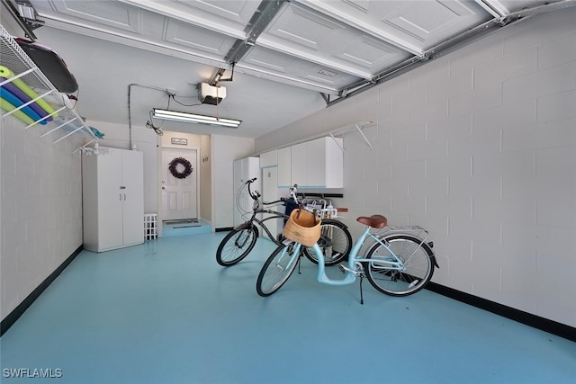 7058 Barrington Cir Unit 102, Naples, FL 34108 - garage featuring a garage door opener and baseboards
