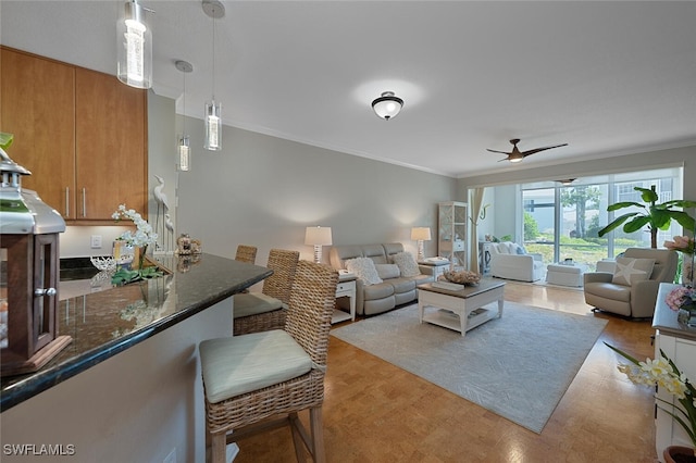 7058 Barrington Cir Unit 102, Naples, FL 34108 - living room featuring crown molding, a ceiling fan, and light wood-type flooring