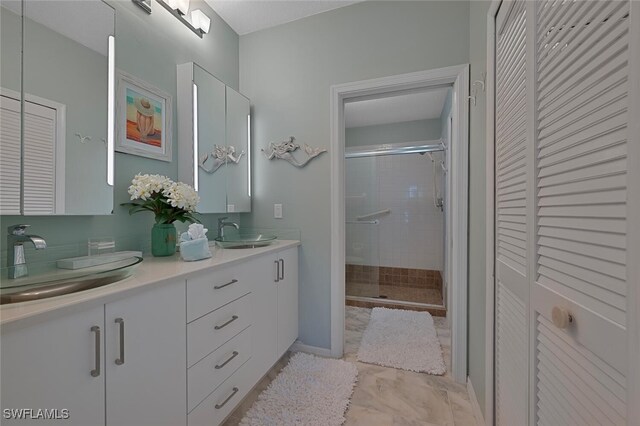7058 Barrington Cir Unit 102, Naples, FL 34108 - full bathroom with a closet, double vanity, a stall shower, marble finish flooring, and baseboards