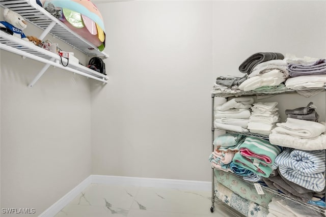 2722 Olde Cypress Dr, Naples, FL 34119 - walk in closet featuring marble look tiles