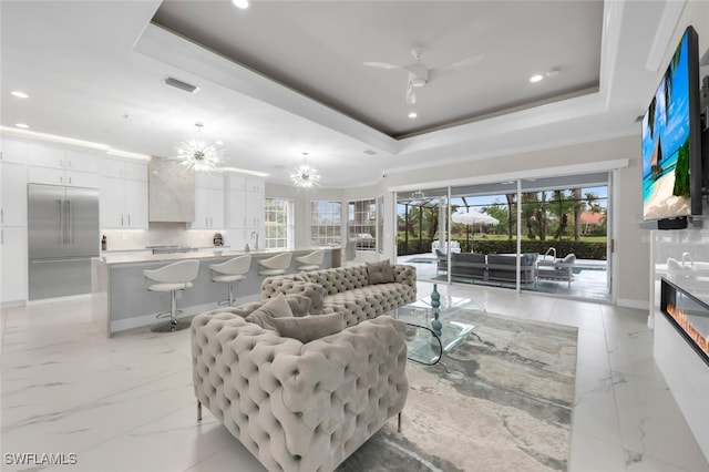 2722 Olde Cypress Dr, Naples, FL 34119 - living area featuring a raised ceiling, ceiling fan, baseboards, recessed lighting, and ornamental molding