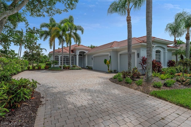 2722 Olde Cypress Dr, Naples, FL 34119 - mediterranean / spanish house with a garage, stucco siding, decorative driveway, and a tile roof