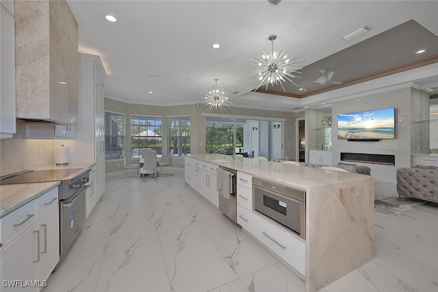 2722 Olde Cypress Dr, Naples, FL 34119 - kitchen featuring recessed lighting, appliances with stainless steel finishes, crown molding, a fireplace, and light marble finish flooring