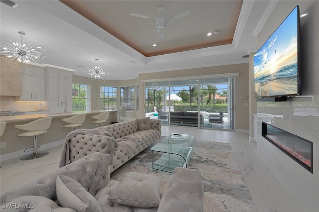 2722 Olde Cypress Dr, Naples, FL 34119 - living room with a chandelier, light marble finish floors, recessed lighting, a raised ceiling, and ornamental molding
