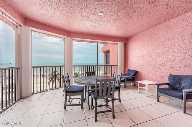 190 Estero Blvd Unit 303, Fort Myers Beach, FL 33931 - sunroom / solarium with a textured wall, a water view, a textured ceiling, and tile patterned flooring