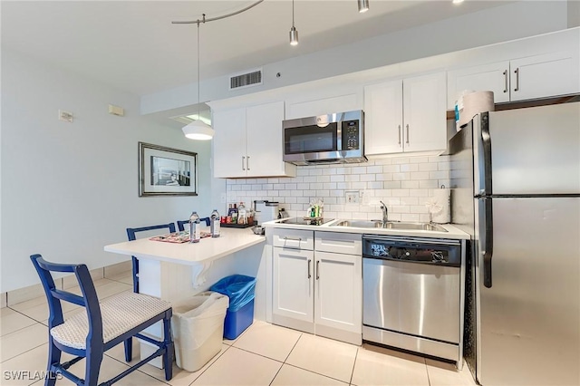 190 Estero Blvd Unit 303, Fort Myers Beach, FL 33931 - kitchen with stainless steel appliances, a sink, backsplash, a peninsula, and white cabinetry