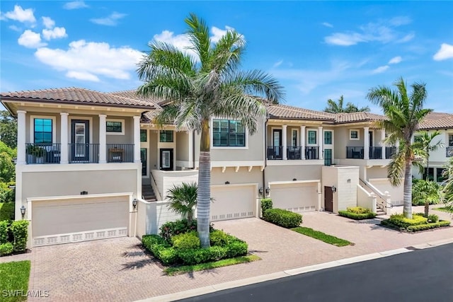 2488 Breakwater Way Unit 201, Naples, FL 34112 - view of front of home featuring a garage, stucco siding, decorative driveway, and a tiled roof