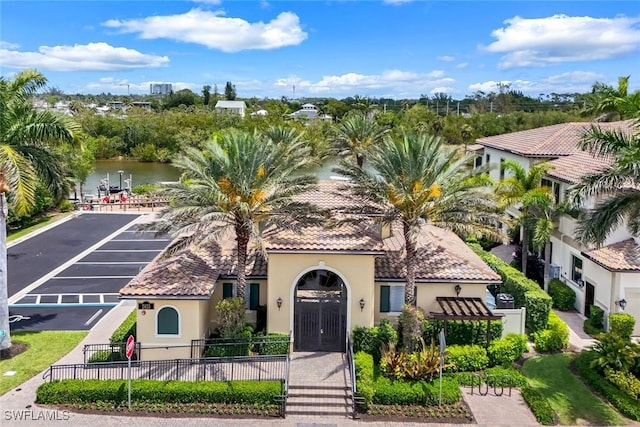 2488 Breakwater Way Unit 201, Naples, FL 34112 - mediterranean / spanish-style home with stucco siding, a water view, uncovered parking, and a tiled roof