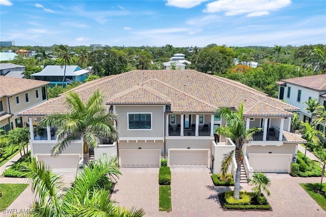 2488 Breakwater Way Unit 201, Naples, FL 34112 - mediterranean / spanish-style house with stucco siding, a garage, a tiled roof, and driveway