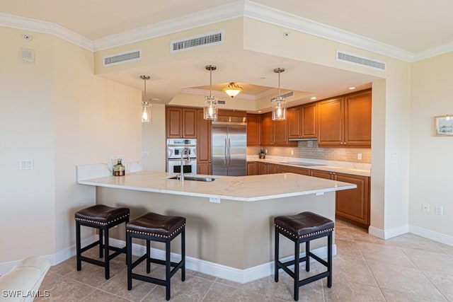 1050 Borghese Ln Unit 1101, Naples, FL 34114 - kitchen with stainless steel appliances, brown cabinets, ornamental molding, a peninsula, and a kitchen breakfast bar