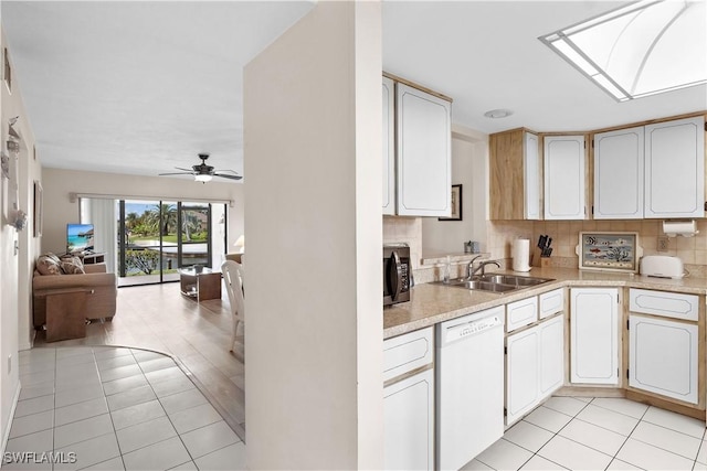 1010 SW 48th Ter Unit 102, Cape Coral, FL 33914 - kitchen with white dishwasher, stainless steel microwave, a sink, open floor plan, and light tile patterned flooring