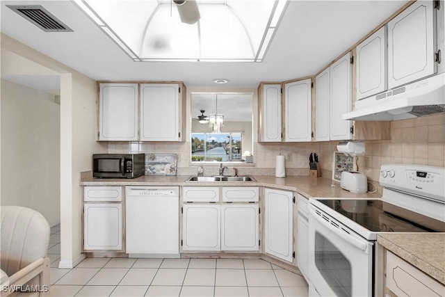 1010 SW 48th Ter Unit 102, Cape Coral, FL 33914 - kitchen featuring white appliances, under cabinet range hood, a sink, backsplash, and light countertops