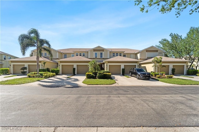 14769 Calusa Palms Dr Unit 203, Fort Myers, FL 33919 - view of front facade with stucco siding and concrete driveway