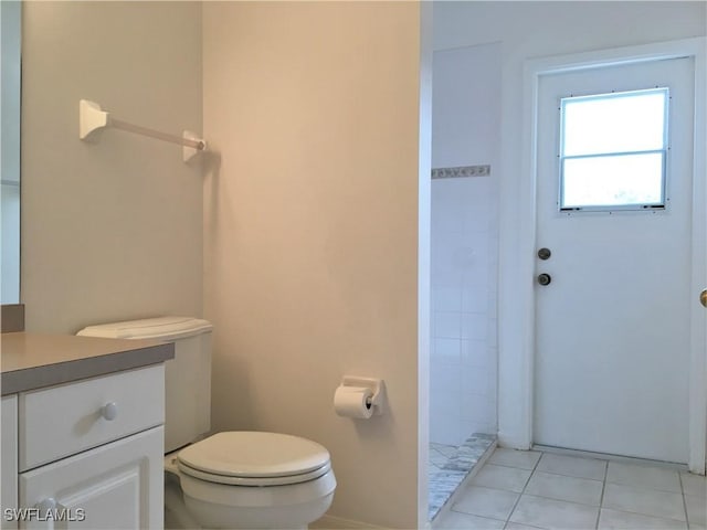 1820 SW 29th Ter, Cape Coral, FL 33914 - bathroom featuring toilet, vanity, tiled shower, tile patterned floors, and baseboards
