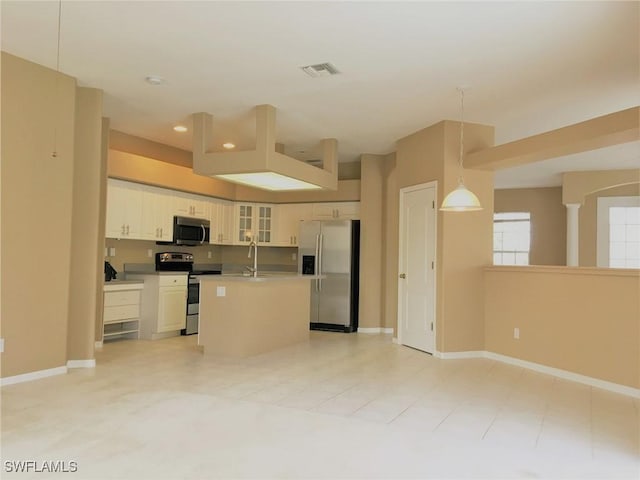 1820 SW 29th Ter, Cape Coral, FL 33914 - kitchen featuring appliances with stainless steel finishes, recessed lighting, glass insert cabinets, a kitchen island with sink, and baseboards