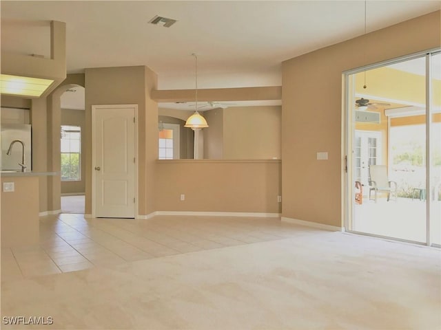 1820 SW 29th Ter, Cape Coral, FL 33914 - carpeted empty room with a ceiling fan, baseboards, arched walkways, and tile patterned floors