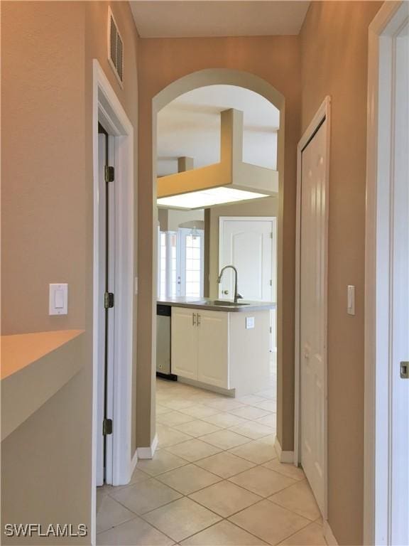 1820 SW 29th Ter, Cape Coral, FL 33914 - hallway with arched walkways, a sink, light tile patterned floors, and baseboards
