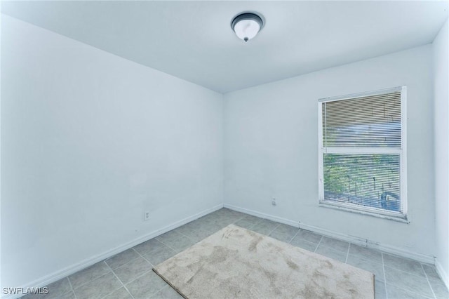 911 Medford Ave S, Lehigh Acres, FL 33974 - spare room featuring light tile patterned floors and baseboards