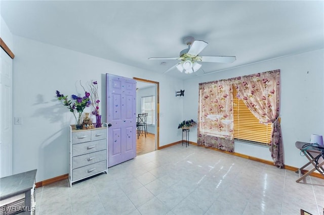911 Medford Ave S, Lehigh Acres, FL 33974 - unfurnished bedroom with baseboards, ceiling fan, and light tile patterned floors