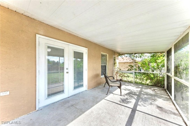 911 Medford Ave S, Lehigh Acres, FL 33974 - unfurnished sunroom featuring french doors, wood ceiling, concrete flooring, and a textured wall