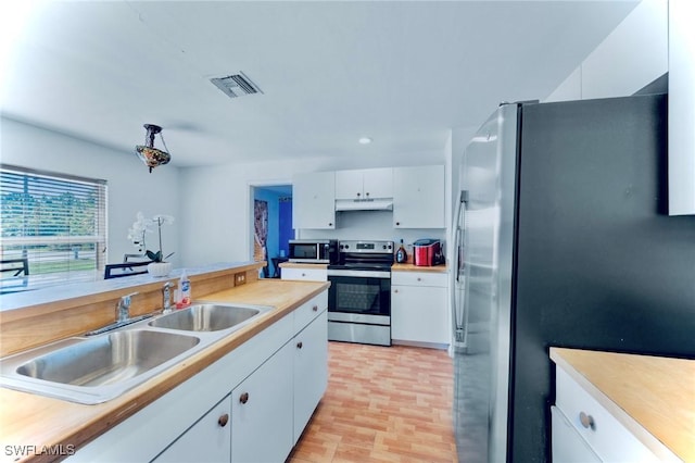 911 Medford Ave S, Lehigh Acres, FL 33974 - kitchen featuring stainless steel appliances, under cabinet range hood, white cabinets, light countertops, and a sink
