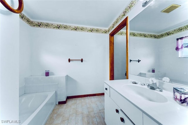 911 Medford Ave S, Lehigh Acres, FL 33974 - full bath featuring vanity, a tub to relax in, baseboards, and wood finished floors