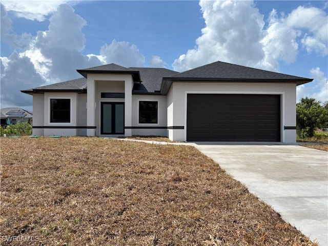 prairie-style house featuring stucco siding, concrete driveway, an attached garage, and roof with shingles