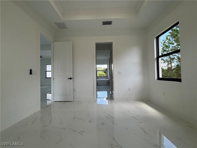 unfurnished room featuring a raised ceiling, marble finish floors, and ornamental molding