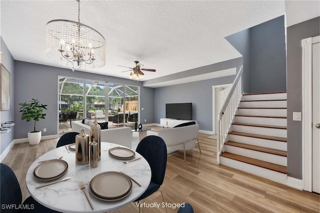 5831 Cove Cir Unit 6, Naples, FL 34119 - dining space with ceiling fan, a textured ceiling, stairway, light wood finished floors, and a chandelier