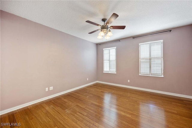 5831 Cove Cir Unit 6, Naples, FL 34119 - unfurnished room with ceiling fan, baseboards, wood finished floors, and a textured ceiling